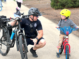 Police Officer showing a young boy how to ride a bike
